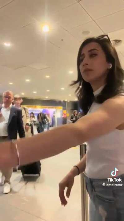 Woman pushes a stranger in front of a camera while filming at the airport 