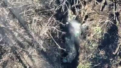 A Ukrainian drone dropping a grenade on two Russian soldiers