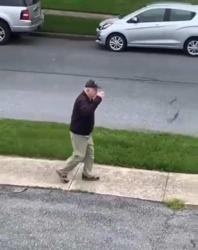 Man on walk stops to salute flag.