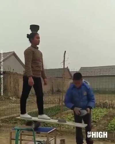 Girl is balancing containers on her head.