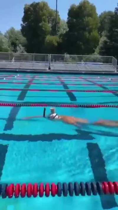 Olympic swimmer keeps head so steady while swimming a glass of chocolate milk placed on her head.