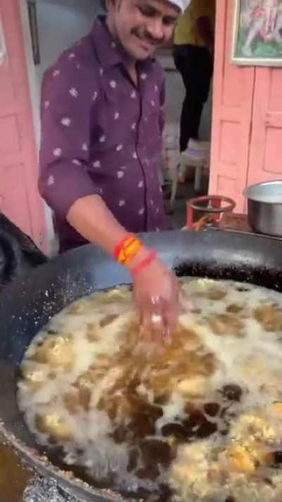 This street food vendor in Jaipur, India puts his hand in boiling oil and nothing happens ….