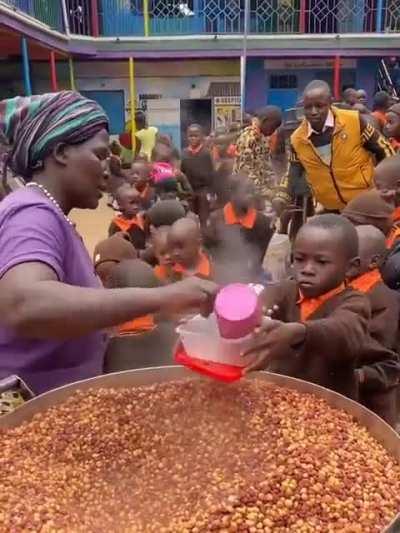 Woman serving Githeri (maize/legumes) in Kenya