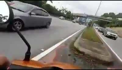 Motorcycle driver helps bunny off the street.