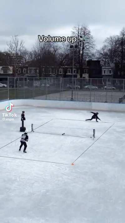 Two Canadians dudes playing tennis on ice.