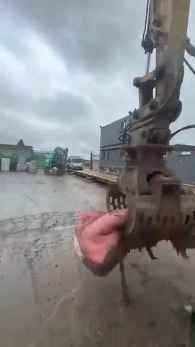 Heavy Equipment Operator 'Mops Up' The Trash At A Dump Site With A Mattress