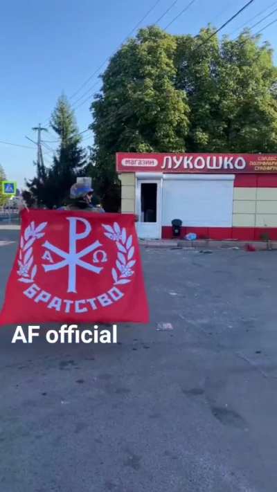 Ukrainian soldiers unfurl their unit's flag in Kursk Oblast, Russia.