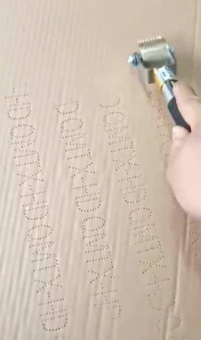 Poking words into cardboard.