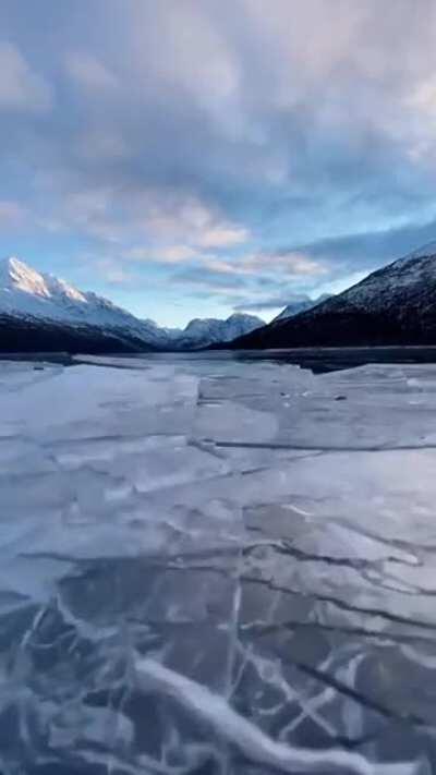 The breaking of newly frozen ice on a lake.