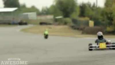 A TWO YEAR OLD racing around the track on a mini bike!