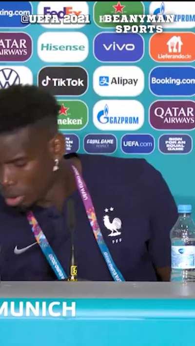 Paul Pogba removing Euro 2020 sponsor Heineken from in front of him during the press conference - credit Beanymansports