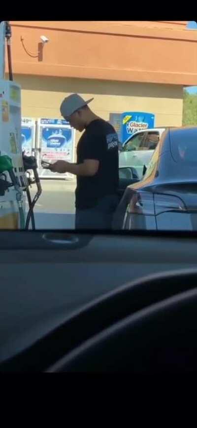 Guy tries to put gas in an electric car