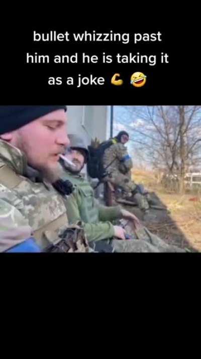 Ukrainian soldier laughs as bullet shoots past him