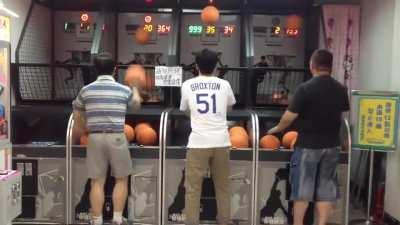 Asian dad absolutely locked in at arcade basketball