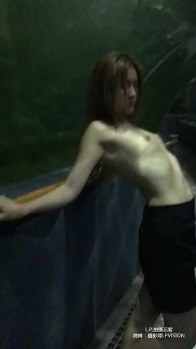 Topless girl do photoshoot at public aquarium