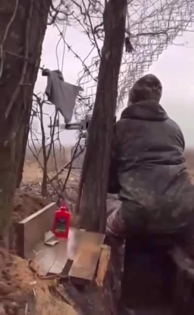 Russian soldier fires heavy machine gun from trench