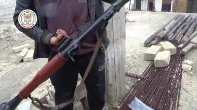 Fighter casually loading and firing RPG-7 in ruined apartment building. Not sure of area outside ME or group (Syria/FSA/Kurd-YPG?)