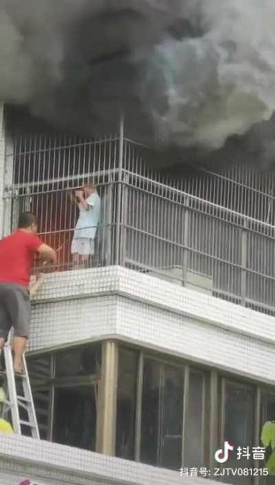 Kid got stuck on balcony when his house is on fire. The balcony has theft-prevention steel fences. Neighbors worked together to cut the fence and rescued the kid.