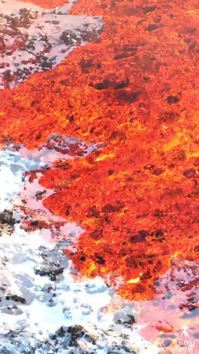 a video of ice and fire - lava flowing over snow