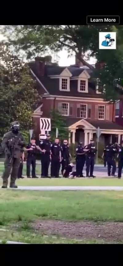 Richmond police officers spitting on a handcuffed protestor.