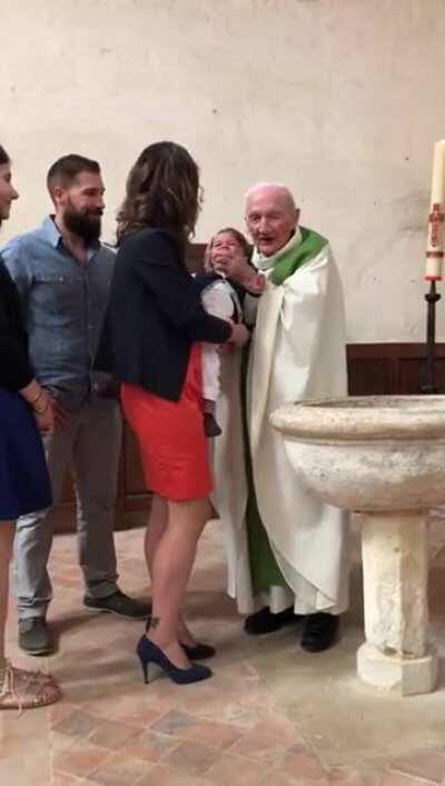 Toddler cries but then got clapped by a priest.