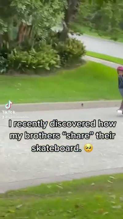 Brothers sharing a skateboard