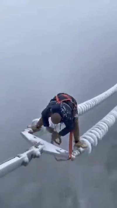 This Chinese worker is working to fix the power in the middle of a storm