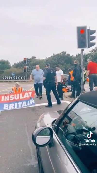 Why are these cops protecting climate activists and preventing civilians from moving them off the road?