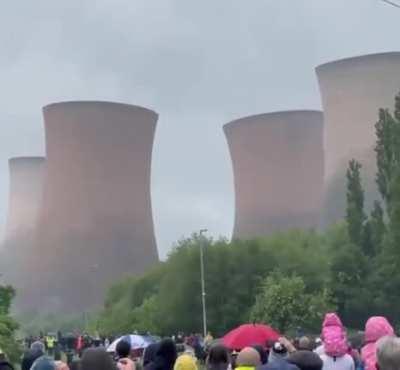 Four giant cooling towers of a power station are getting toppled.