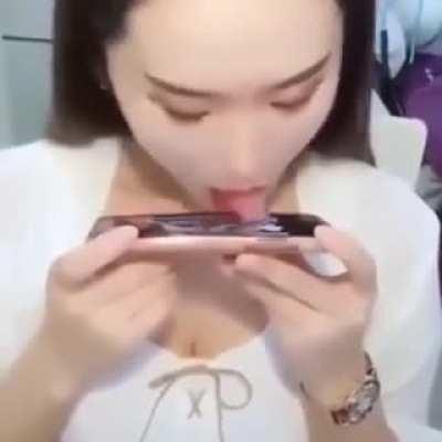 Girl playing phone game with her tongue