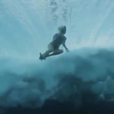 Person tumbling, rolled by wave