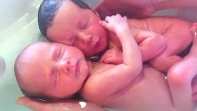 Very recently born twins are placed under water, and think they're still in the womb....