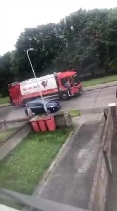 Man unhappy garbage truck is delaying him.