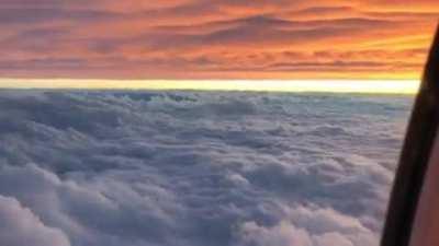 Plane flying in between 2 layers of clouds