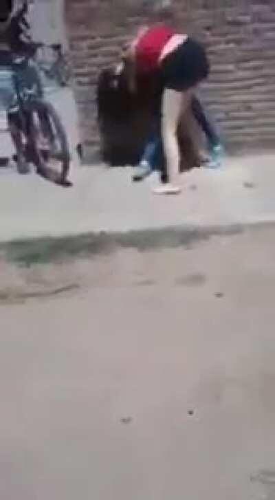 Mother encouraging her daughter in a street fight, somewhere in Argentina