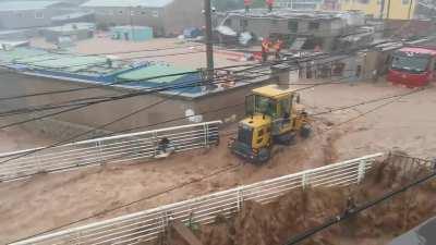 Gigachad Man in a tractor loader risk his life saving a family of 3 stuck in a fast moving raging flood