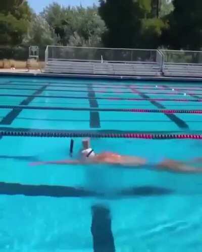 Olympic Gold Medalist, Katie Ledecky swims with a glass of chocolate milk on her head