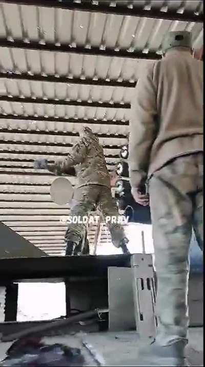 Russian soldiers next to a RBU-6000 naval rocket launcher that was mounted on top of a vehicle hit a rocket with a hammer to load it in