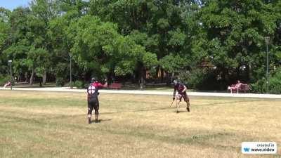 Two guys with whips sparring in the park