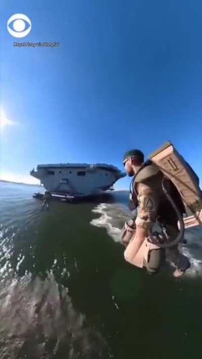 People flying jetsuits as British Royal Navy Aircraft Carrier HMS Elizabeth enters New York Harbour.