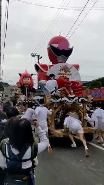 This is Harimichi, a Japanese festival in Nihonmatsu held annually in October, where giant dolls are made to crash into each other to pray for a good harvest (in the video, the current Red Ranger is crashing into Anya of Spy x Family)