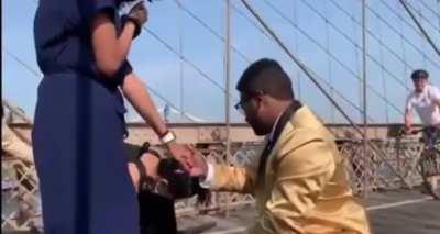 In the midst of the Brooklyn Bridge, making a proposal