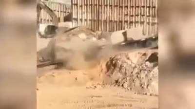 An excavator saves a loaded truck leaving a quarry when its drivetrain fails