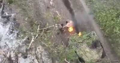 Russian soldier unsuccessfully attempts to extinguish the flames on his comrade who is engulfed in fire following a strike