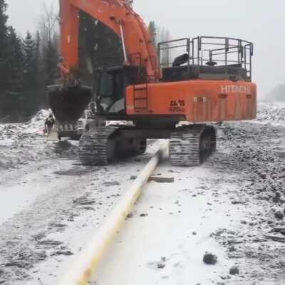 Heavy machine operator avoiding a pipe