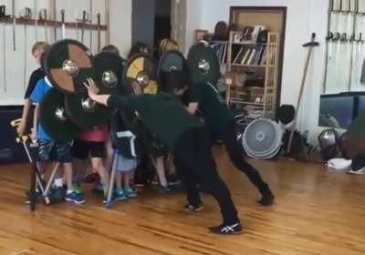 Group of students learning the strength of a proper shield wall