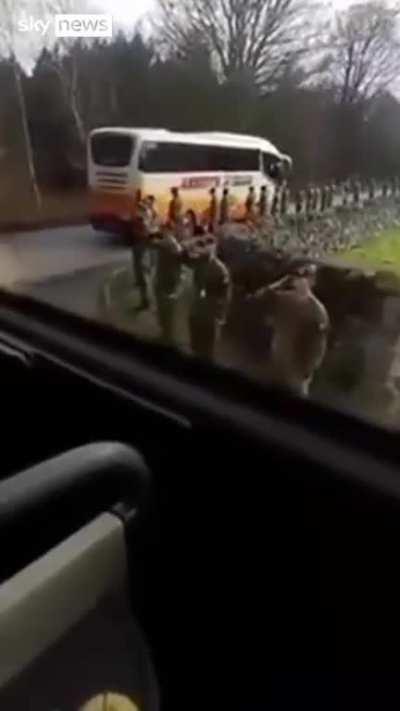 British soldiers salute Ukrainian troops as they leave Britain for the front line