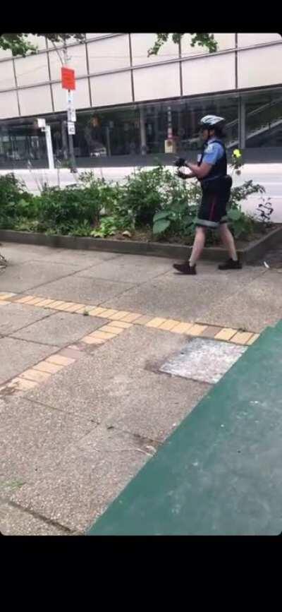 Toronto city worker finds police officers placing rocks on the curb amid oncoming protesters.