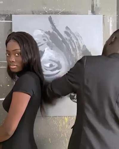 Guy paints girl using her hair