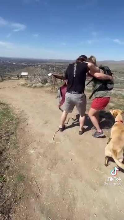 Snake prank while hiking. Very smart, tie the snake by a line to the prankee.